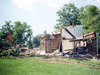 Demolition underway in August 2004 reveals the two original underlying log structures, one housing the kitchen (right foreground) that was built behind the other original main living quarters (left background).